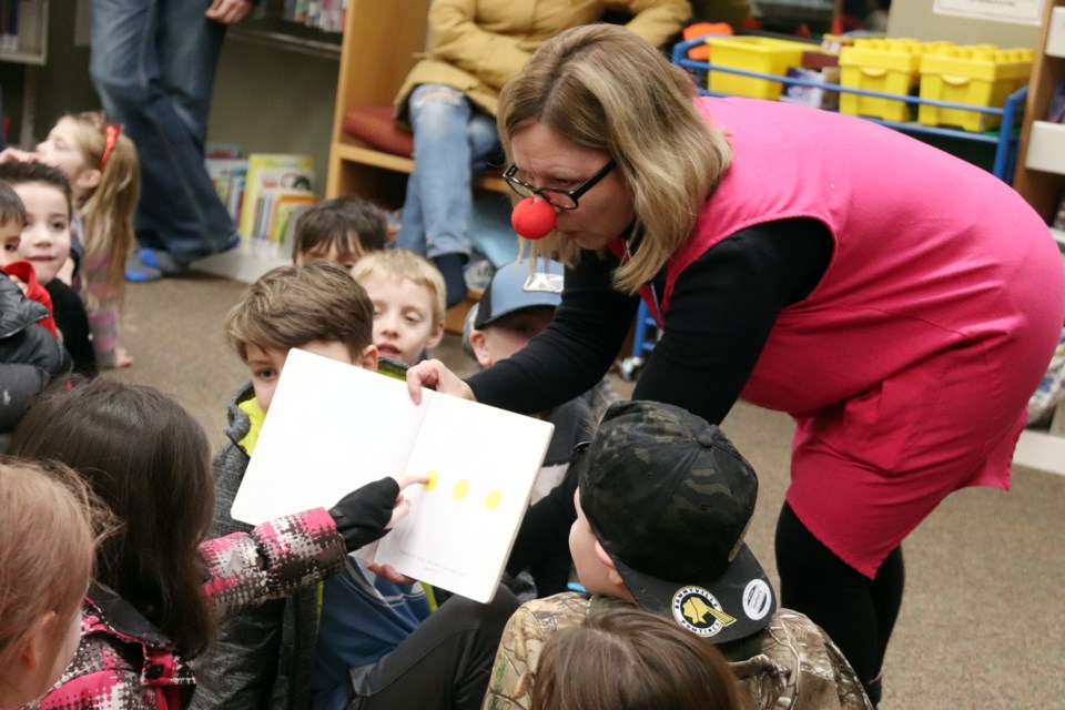 Library manager Leah Woodford read "Press Here" an interactive story that had children pressing, rubbing, wiggling, and acting out various instructions throughout the story. Photo by Meagan MacEachern.