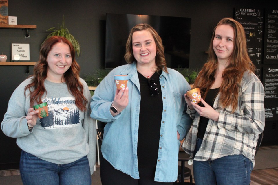 Heidi Debusschere, Coun. Kayla Blanchette, and Aleesha Cabay from the Bonnyville FCSS hosted a free women's night, where attendees gathered to paint flower pots together, as a way to promote mental wellness through connection to community.
