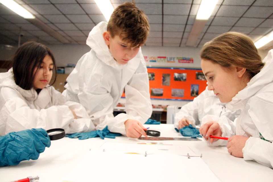 Students learn how to dust for fingerprints during the school resource program Crime Scene Investigation sessions. File Photo