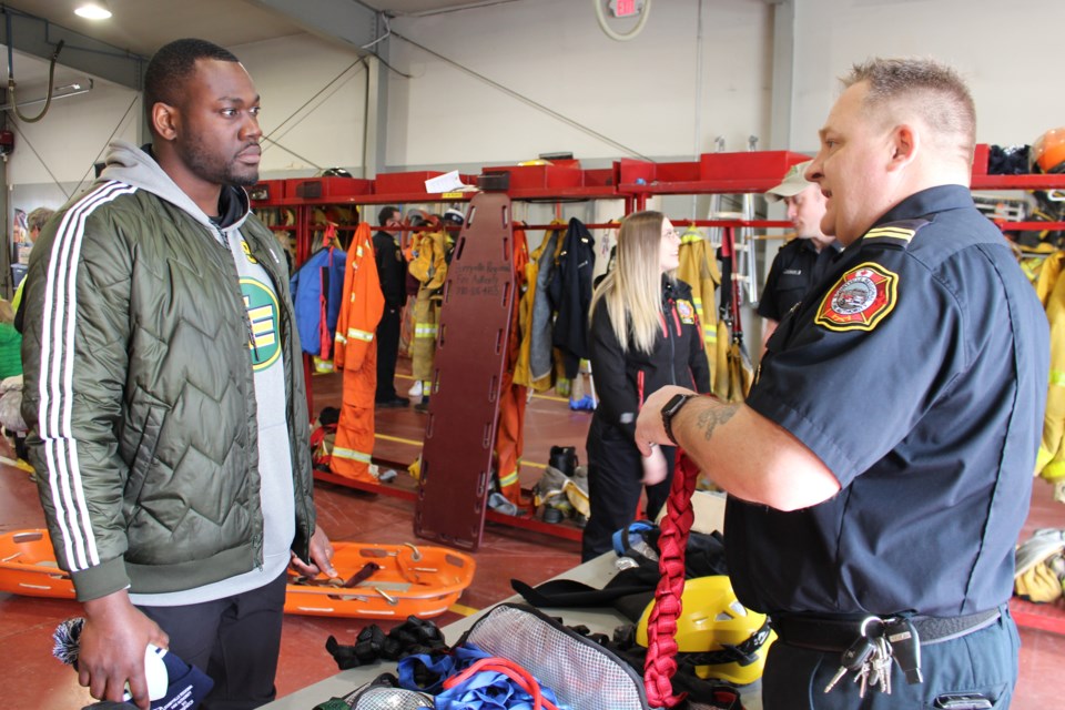 Edmonton Eskimo defensive-end Kwaku Boateng (left) listens to Bonnyville Regional Fire Authority regional training and fire prevention officer Capt. Dwayne Ethier. Photo by Robynne Henry. 