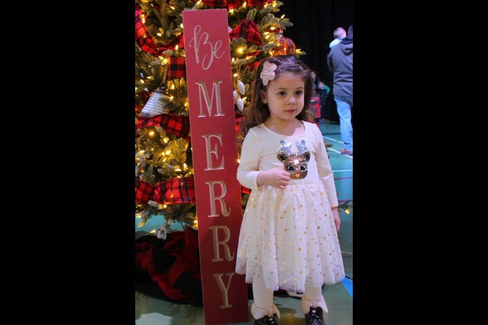 Three-year-old Isadora Schafer posed for a photo beside one of the trees. Photo by Robynne Henry