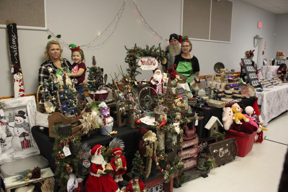 Vendors brought their Christmas wares for the Cherry Grove Christmas Bazaar. From the left, Darlene Zilinski with young Mia Savic at their Gathering Daisies booth, and Brent and Ann Ripley at their Ann Made booth.