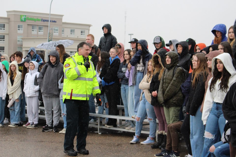 Bonnyville Regional Fire Chief Dan Heney explains to students what is taking place as the mock collision unfolds in front of them.