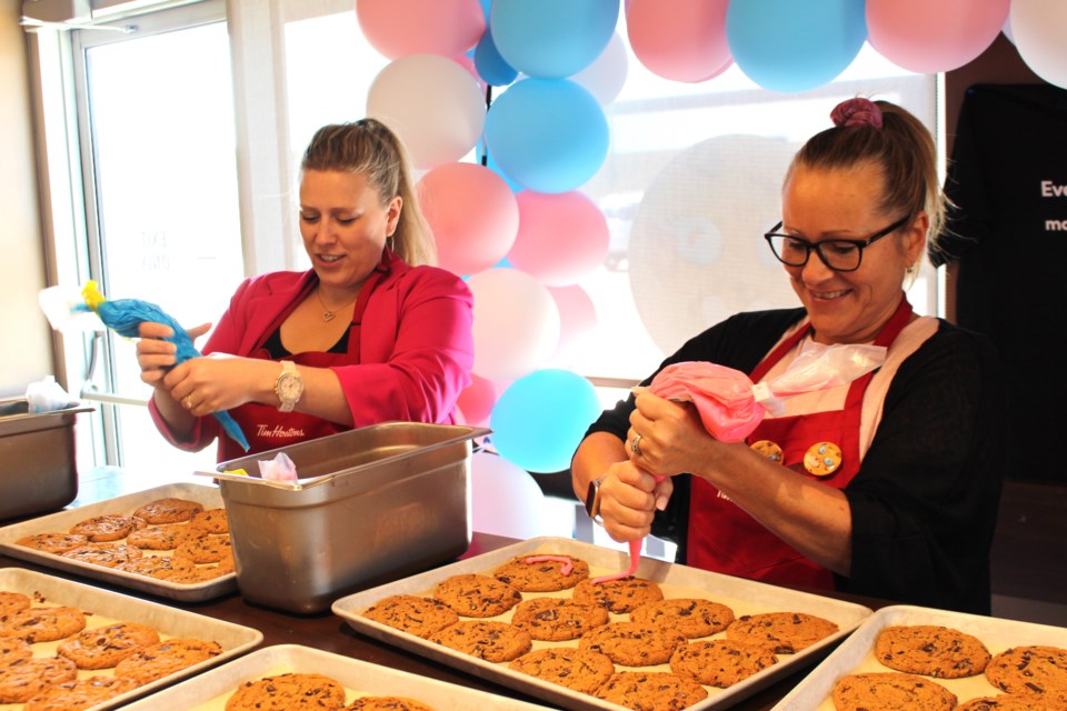 Kim Foisy (right) and Carrie Baumgardner (left) took some time from their work at Canadian Natural Resources Ltd. to head over to the west end Tim Horton's in Bonnyville to add smiles to cookies. This is the pairs first year taking part in the Smile Cookie campaign.