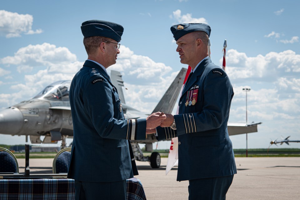 1 Canadian Air Division Commander, Major-General Eric Kenny, present the 4 Wing sword to the incoming 4 Wing Commander, Col. Dave Turenne during the 4 Wing Change of Command Ceremony at 4 Wing, Cold Lake, on June 3.