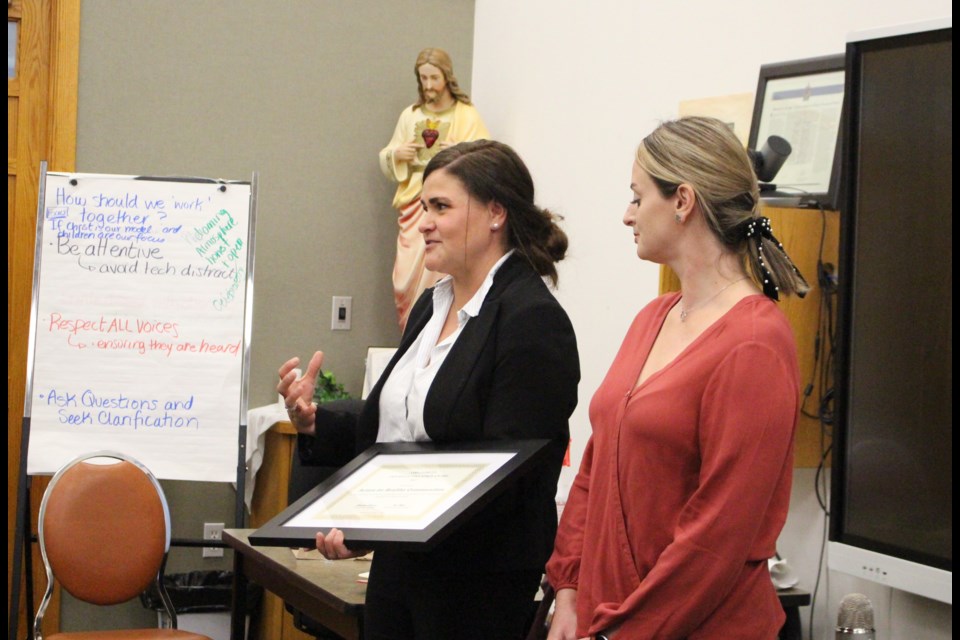 Paola Corbi de Shank and Oskana Vallee accept a Friends of Education Award on behalf of Action for Health Communities during an Oct. 19 Lakeland Catholic board meeting.