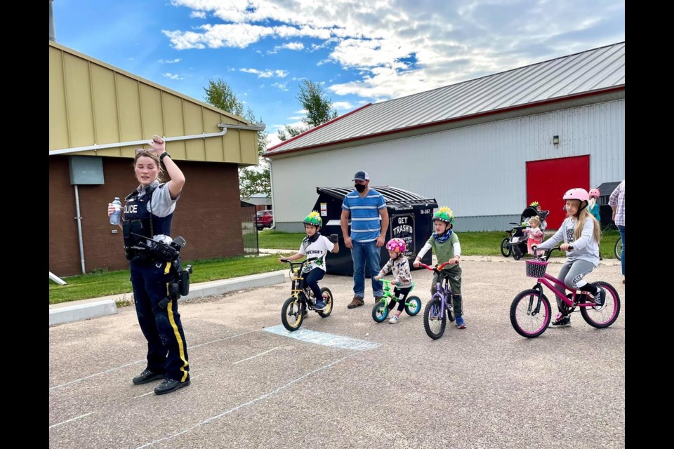 RCMP Officer  Katherine Hall  demonstrates hand signals for youth attending the Bike Safety Rodeo. 