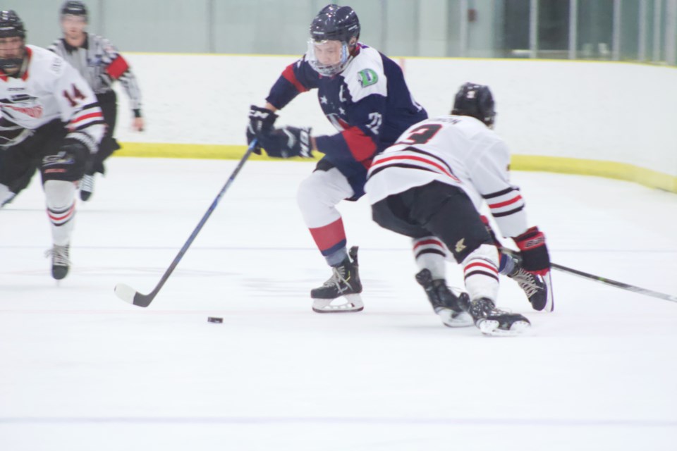 Clippers Peter Willier partially dodges a low check from a Bandit player during Saturday's home ice win. Willier had a successful night with three goals and two assists.