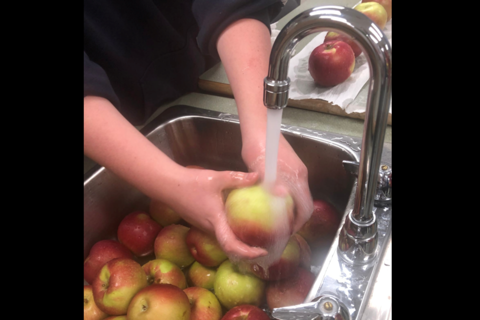 An Aurora student prepares the weekly produce delivery for their school's fruit bin program in Lac La Biche. 