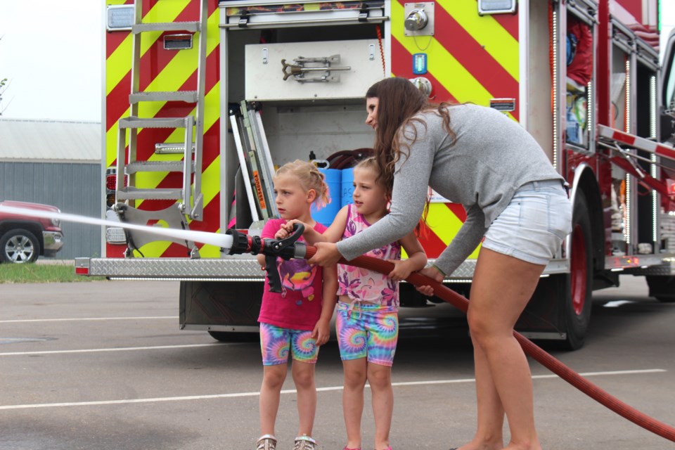 Peyton and Naomi Sulz get help putting out pretend fires with a hand from Alexandra Zanussi.