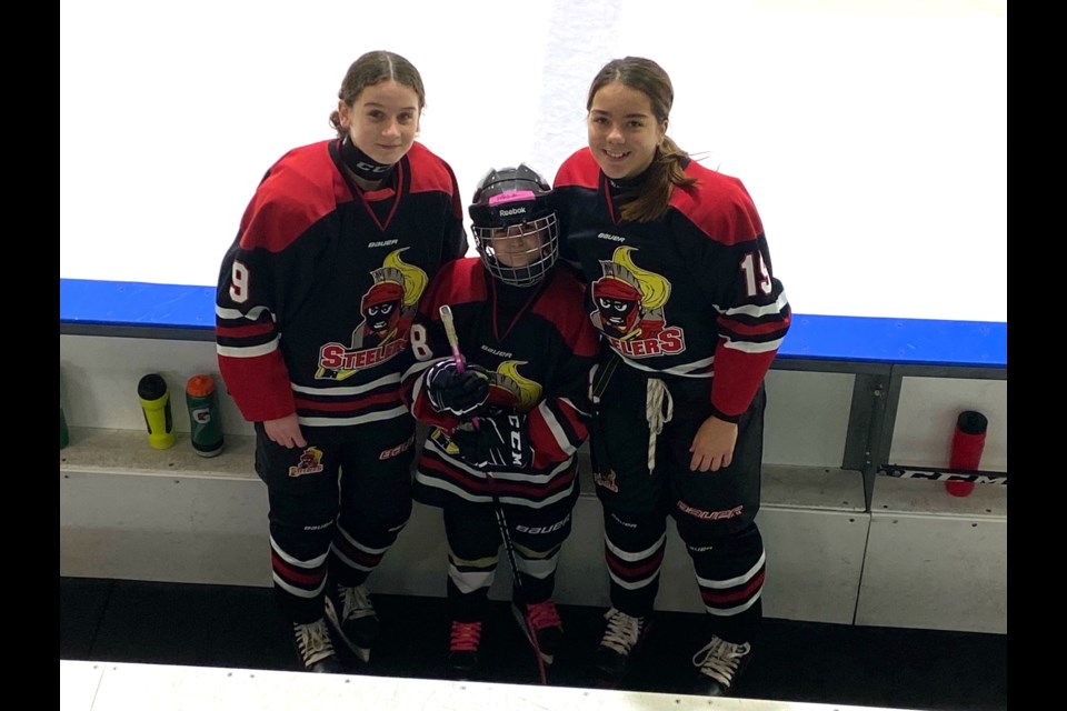 The Lloydminster Richardson's Jewellery U15 AA Jr Steelers' players Kalie Cole (left) and Brooklyn Vachon (right) welcomed Mia Chappell, a Bonnyville Minor Hockey Association U9 player, as the Steelers' honourary captain for the day.