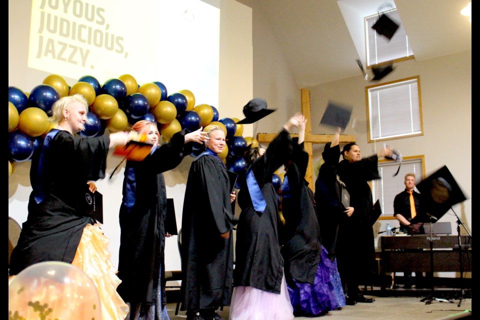 Bonnyville Outreach School 2022 graduates toss their caps.