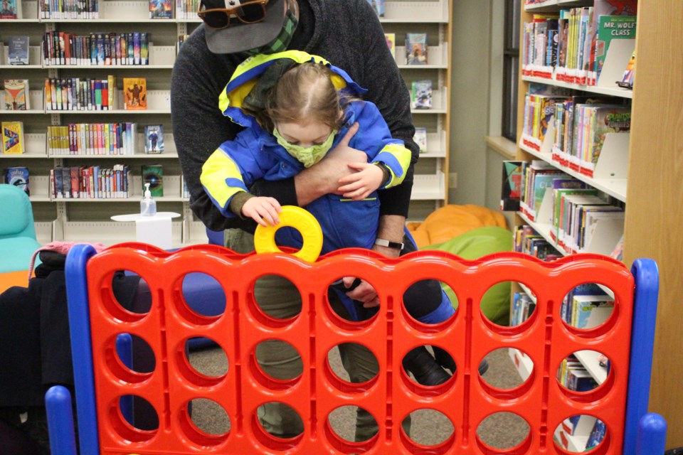 Freyja and her father Chris Eliason play Connect Four in the Bonnyville Municipal Library during the Family Literacy Day event.