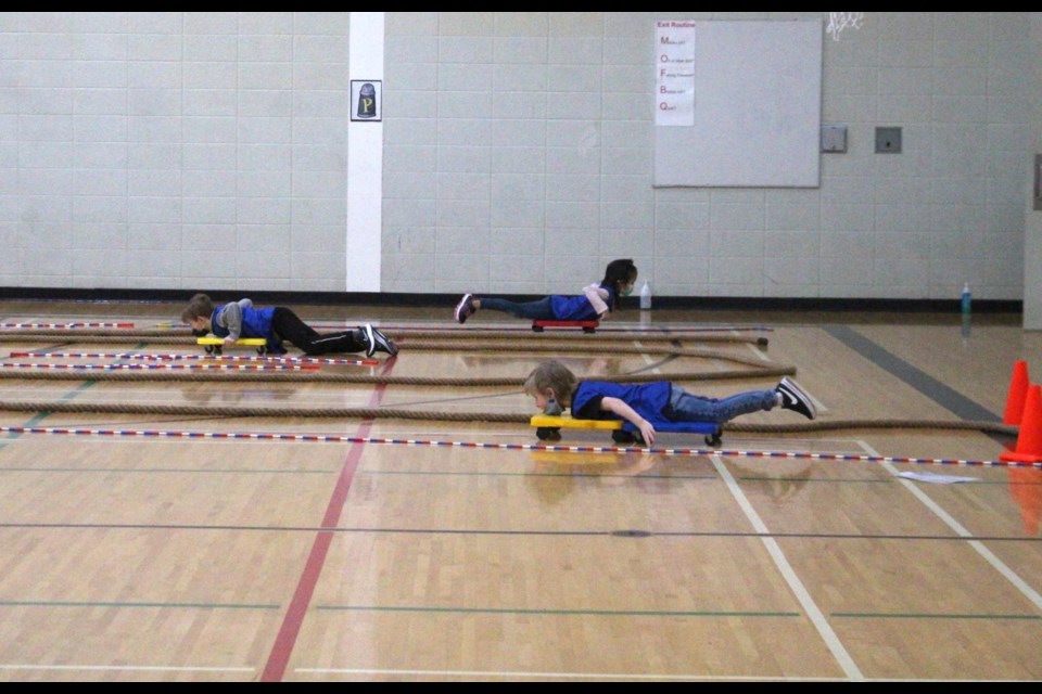 Duclos students practice their bobsledding techniques while on rolling platforms.