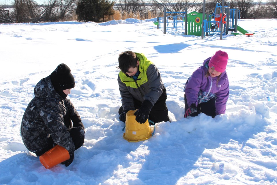 Gage Carlin, Avery Mitchell and Mckinlee Mitchell worked on the foundation of an igloo at the youth event organized by the Bonnyville Friendship Centre on Feb. 12.