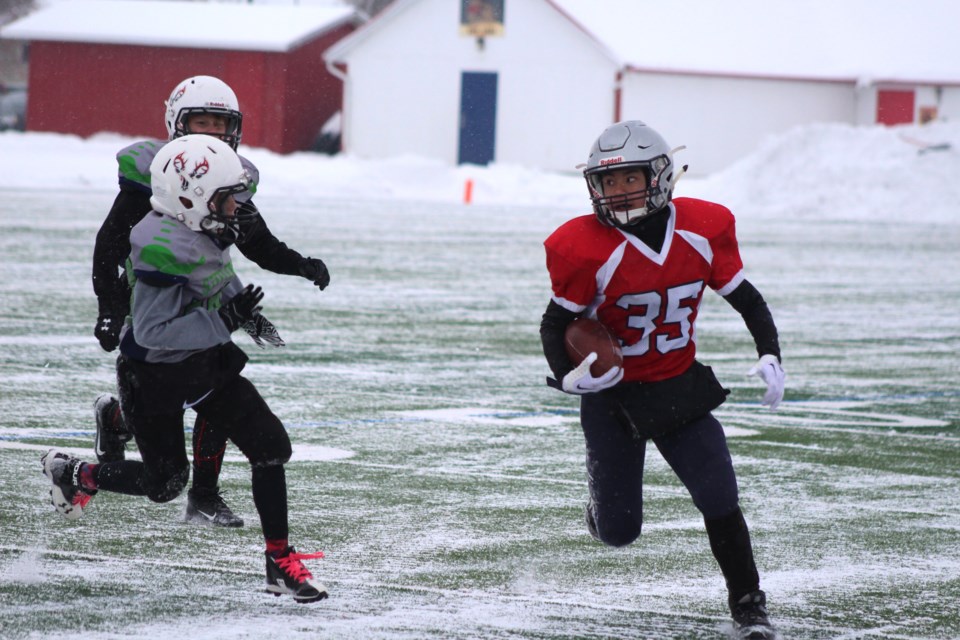 Renegades player #35 Justin Agbanlong makes a several yard run as he doges the Red Deer Steelers defensive line. 