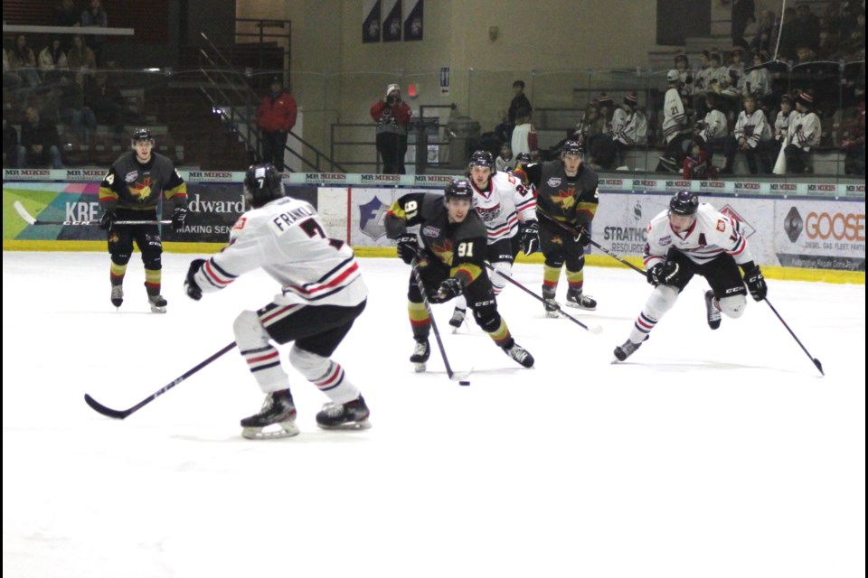 Pontiacs' player Sebastian Tamburro pushes down the ice past several defensemen to make a shot on net.