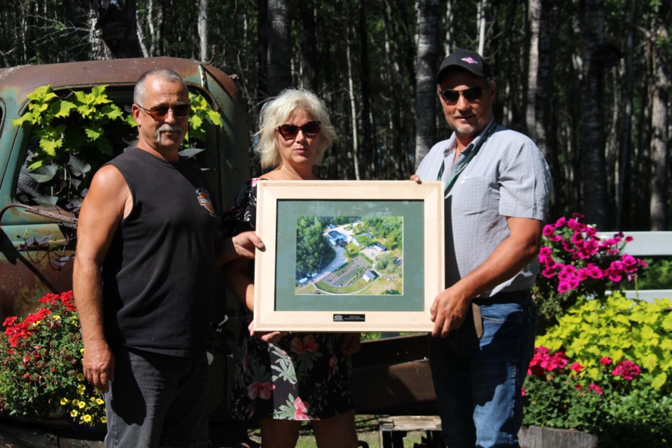 Daryl Knapp (left) and Sherry McGinnes (centre) receive the 2022 Rural Beautification Acreage Award.