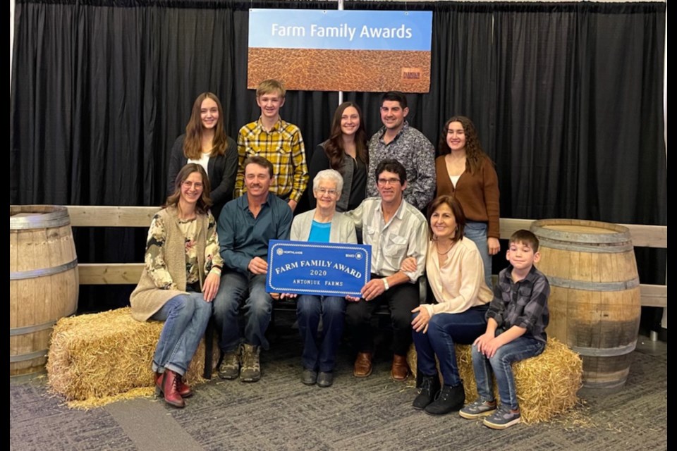 On Nov. 12, the Antoniuk Farm received a commemorative gate sign to signify that the multi-generational farm had received a 2020 Family Farm Award in recognition of their farming business practices and community involvement. (Standing left to right) Merissa, Braden, Kyla, Kurtis and Kristin Antoniuk. (seated left to right) Diane, Ken, Jean, Roger, Suzanne and Carson Antoniuk.