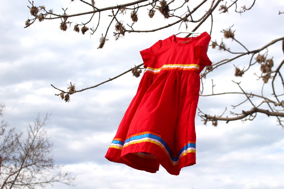 A child's red dress hangs from a tree along Highway 28 to represent the Missing and Murdered Indigenous Women and Girls. 
