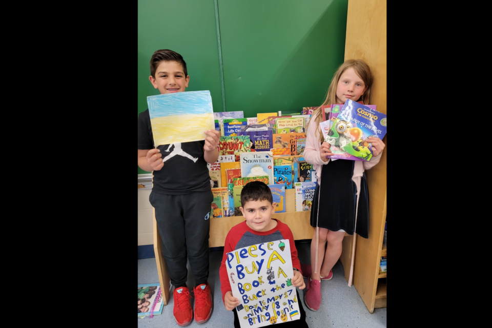Verma M. Welsh students from Shelly Thody's Grade 3 class led a school-wide fundraiser raising $600 in proceeds from selling donated books for $1 each. The proceeds raised by the 24 students will be going to help Ukrainian communities impacted by the Russian-led war. Pictured are Grade three students  Amir, Yehya and Rayna (left to right).