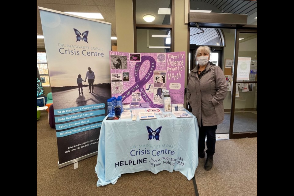 Lil C., a community support worker, stands at one of DMSCC's rotating informational displays made especially for Family Violence Prevention Month. The display was at the Bonnyville Municipal Library during the first week of November.