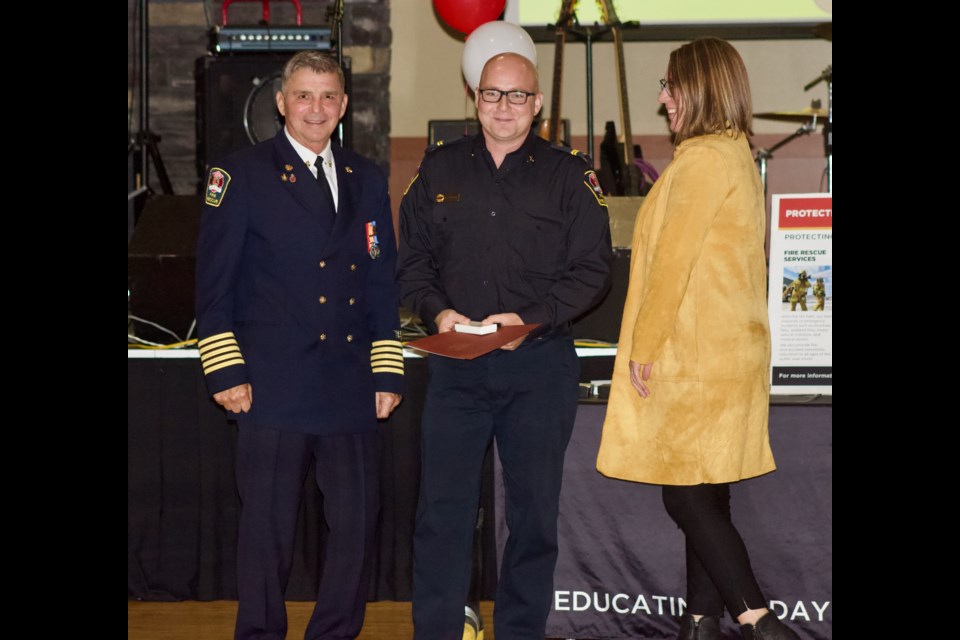 Regional Fire Chief John Kokotilo (left) and  County Coun. Charlyn Moore (right) presented Capt. Draper Dempsey with the 12-year Provincial Medal during the firefighter awards ceremony on Sept. 17, 2022.
