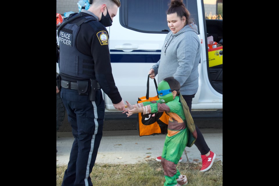 Peace Officer Ben Laboucane having a little fun with ninja turtle trick-or-treater on Halloween night| Lac La Biche