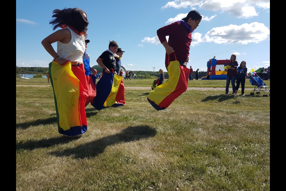 Older kids attending the Mission picnic jumped at the chance to compete in a sack race.