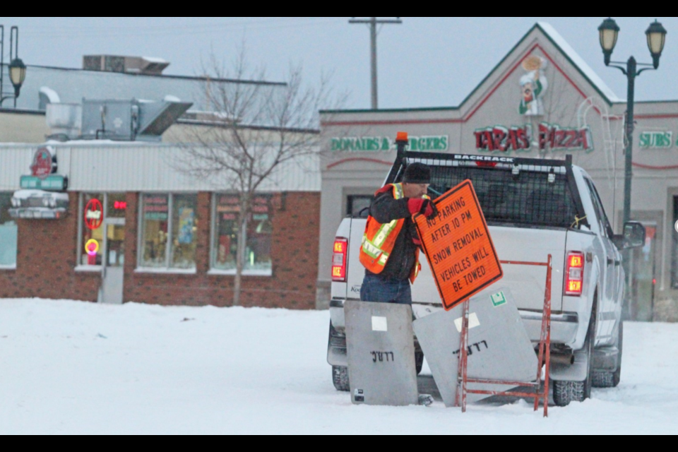 Lac La Biche County Transportation supervisor Barry Feledichuk puts out road-clearing reminder signs along Main Street late afternoon on Tuesday, as the most recent snowfall blanketed the region