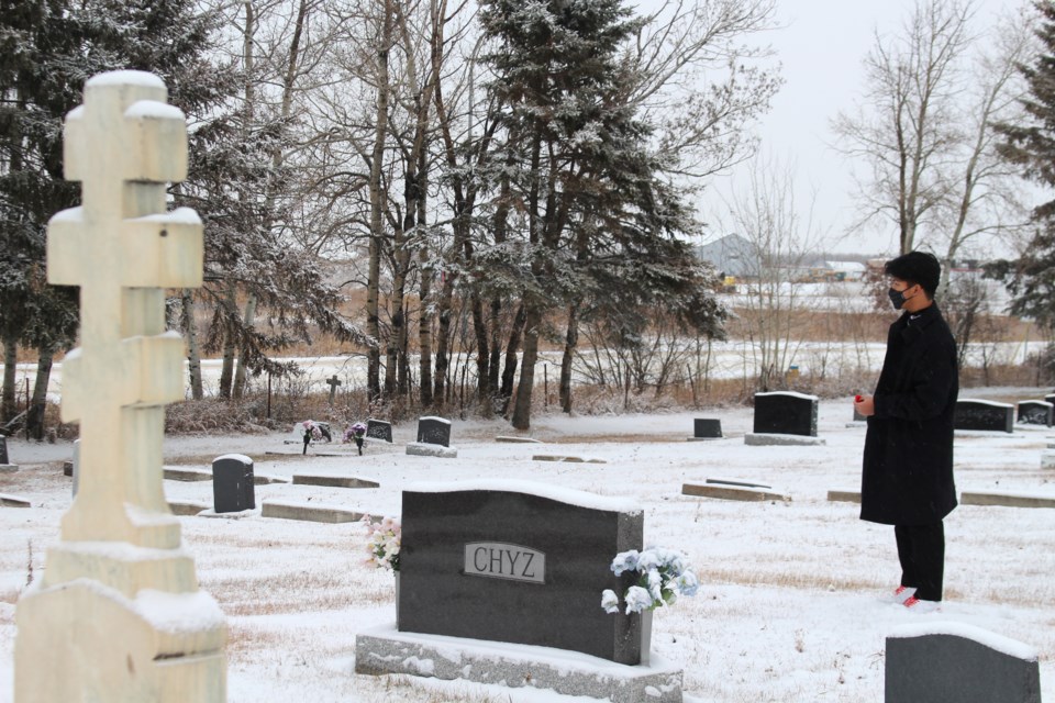 Grade 12 student, MJ Cuma reads the headstone and recites a prayer before laying a poppy.