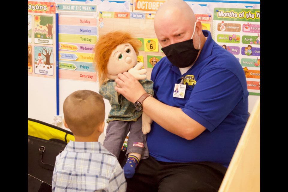 Instructor Justin Anderson and puppet Aaron from Safely on Board, teaching preschool students at Light of Christ Catholic school about bus safety. Lac La Biche 