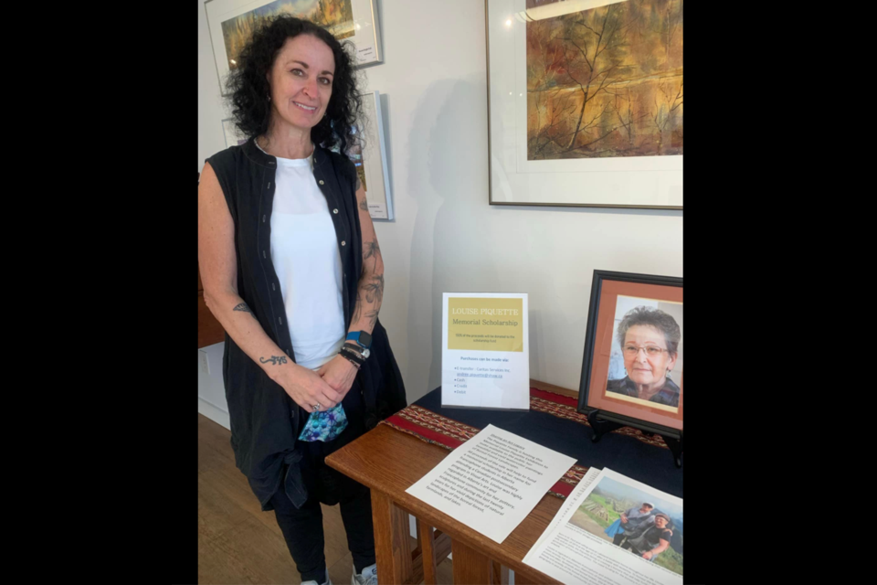 Last summer, a framed image of artist Louise Piquette was displayed at the Lac La Biche Farmers Market. The late artist's work was on display and for sale throughout the summer of 2021. Proceeds from the sale went to support a unique bursary for young Francophone art students. Pictured is Piquette's daughter Sue LaPierre.