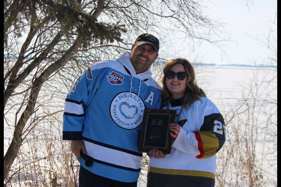 Reeve Barry Kalinski presents Deputy Mayor Kayla Blanchette with a plaque from the MD of Bonnyville congratulating the town on its 75th anniversary.
