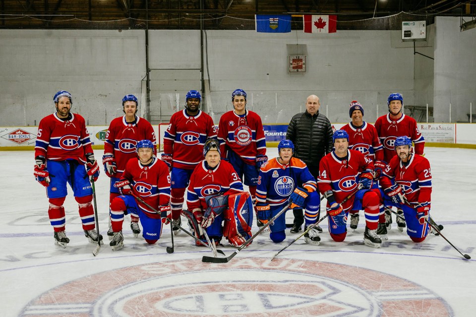 Montreal Canadiens' alumni, along with Jr. B Canadiens' player Louis-David Fournier, who is originally from Québec, pose for a group photo at centre ice, following Saturday's alumni game.