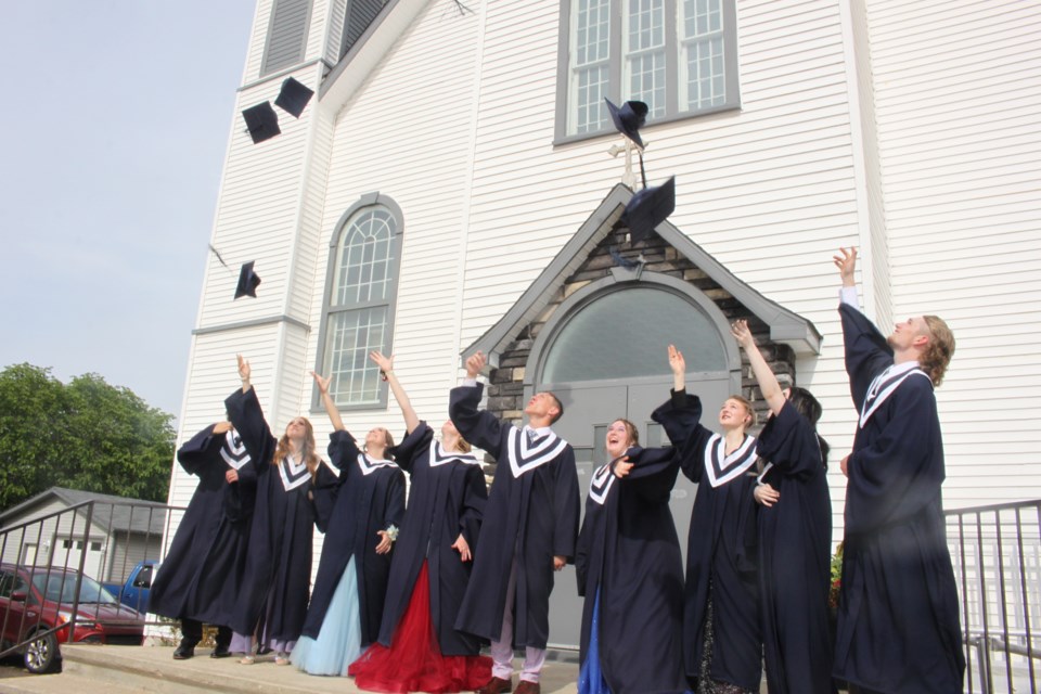 The Class of 2023 from Ecole Beausejour toss their grad caps to the sky on the steps of Plamondon's St. Isidore Church at their recent graduation day.