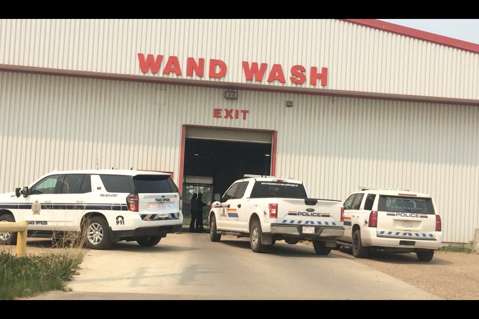 Lac La Biche RCMP and community peace officer vehicles block one doorway of Louis' Car Wash in Lac La Biche. Moments earlier police say a vehicle crashed out of the businesses as police responded to an alleged fraud complaint. 