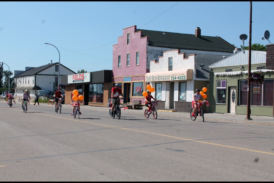 Bouquets of orange balloons adorned the bicycles of youngsters leading the bike parade up Elk Point’s main street on Canada Day, in recognition of the tragic losses of life at residential schools across the nation.