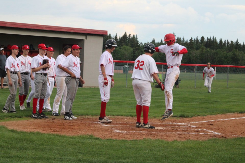 A brief celebration: Cold Lake Cardinals hitter Cody Archibald jumps onto home plate as he'd congratulated by teammates on a home run during Thursday night's loss to the Lac La Biche Dodgers at Cold Lake's Imperial Park Sports Field. The Dodgers won the game 17-9, taking the Lac La Biche team into the Lakeland Minor Ball league championship finals next Thursday. Games are being played early next week to determine who the Dodgers will play against.