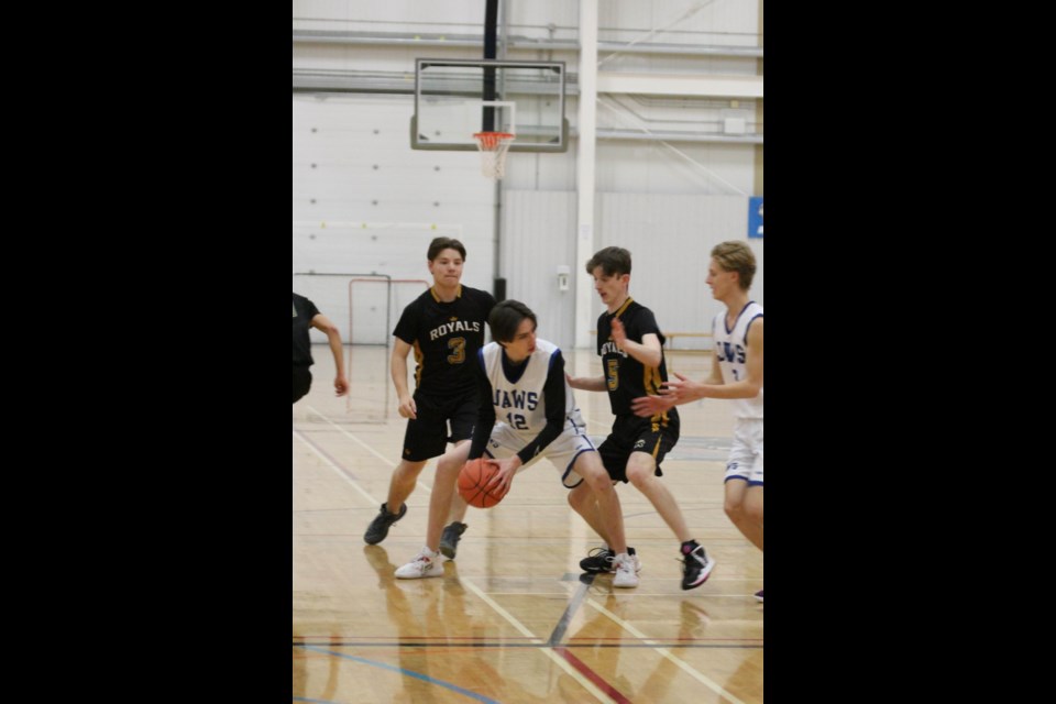 JAWS player Justin Ward (12) looks for a passing lane around Royals' Ryker Neumier (3) and Jack Nichol (5).