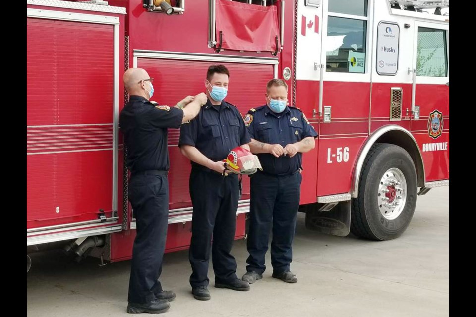 Station 5 Cpt. Craig Wenzel (left) adds another bar to the shoulder of Colin Atkinson to signify his promotion to captain. Photo submitted. 