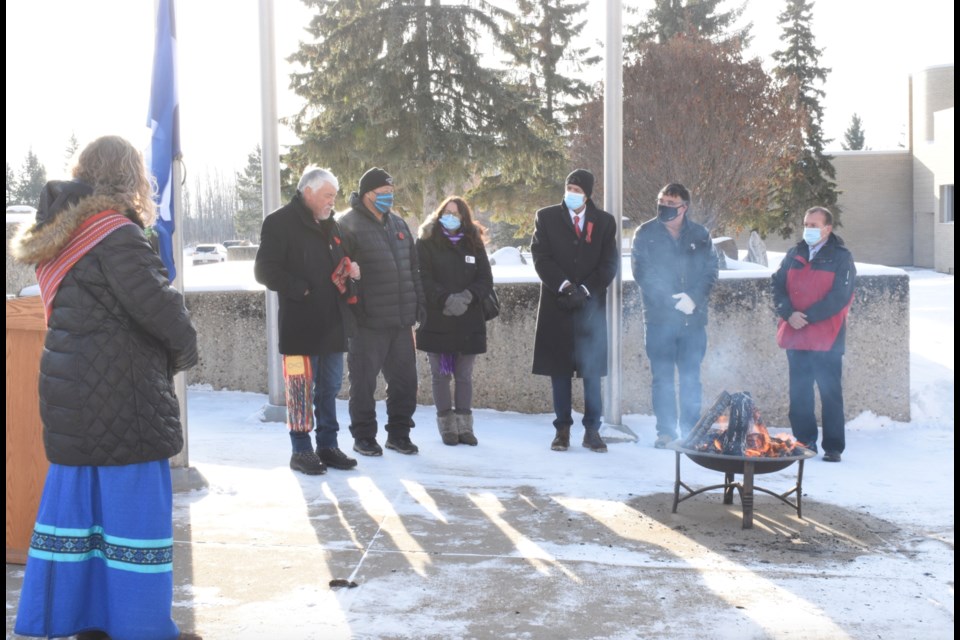 Portage College President Nancy Broadbent (left) watches with others as the Metis flag is raised to celebtrate the start of Metis Week    Image Bianca Mazziotti.