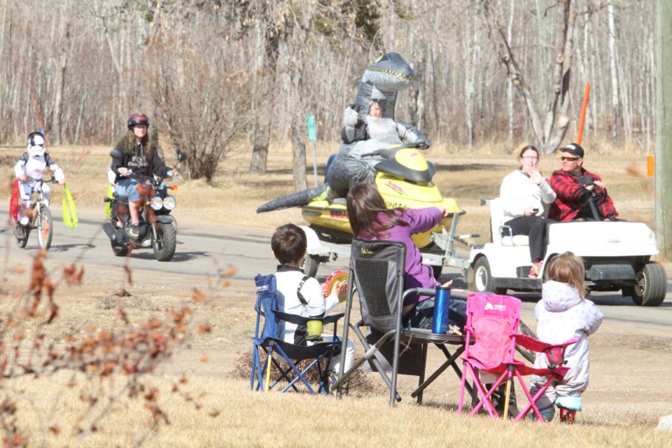 A family watches part of a recent COVID convoy through a Lac La Biche subdivision.