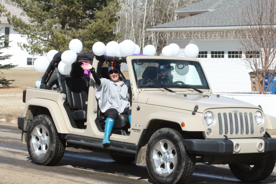 Charissa Delaire, one of the parade's organizers, waves from a neighbourhood float.