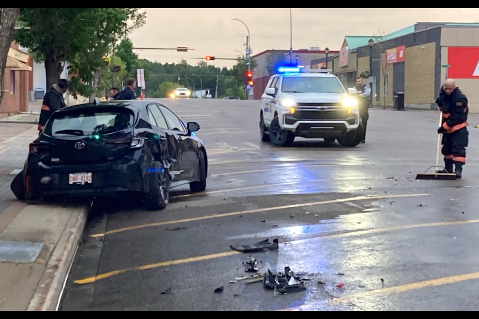 Firefighters clean up debris and fuel that was left at the scene of the first of three, chain-reaction collision=s on Wednesday night along 101 Street in Lac La  Biche.