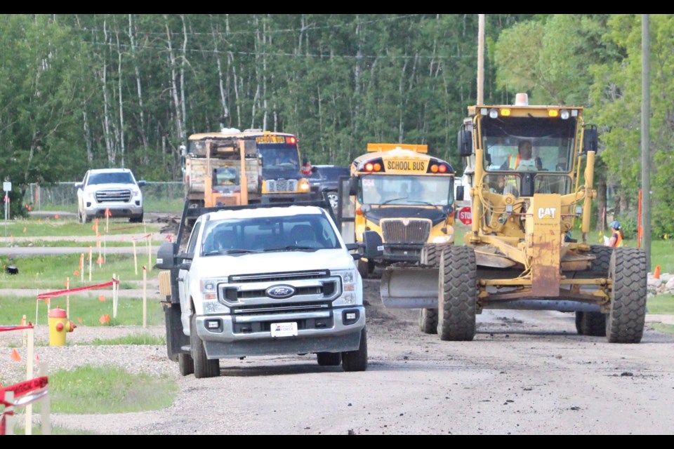 Two school buses wind their way through construction along West Road in the Beaver Lake hamlet (Young's Beach) on Tuesday afternoon. Municipal crews and contractors were beginning the first stage of the $3.4 million paving project for the subdivision.

