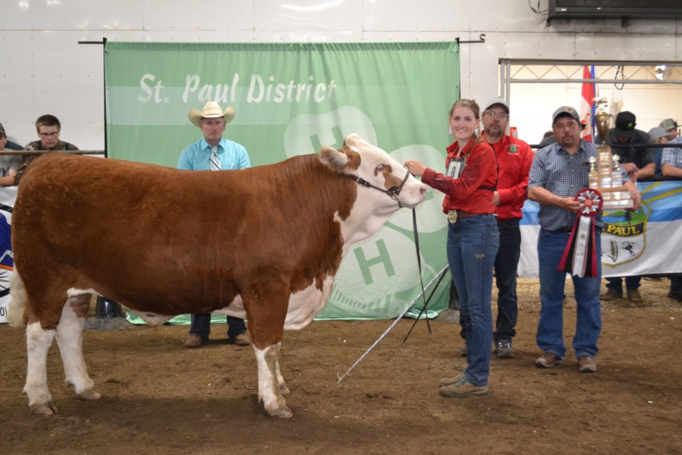 A beaming Cloey Germain of the Elk Point 4-H Beef Club proudly shows off ‘Wilson’, her St. Paul 4-H District Grand Champion Steer, with purchasers Dennis and Paul Kotowich of Kotowich Evergreen Farms presenting the trophy and judge Lance Leachman adding his congratulations on the win.