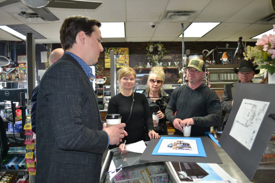 Minister of Transportation and Economic Corridors Devin Dreeshen (left) gave his input on the plans displayed by Loree Reynolds, Elaine, Aaron and Harvey Aarbo for modernization and expansion of their family business, the Outrider Truck Stop, and the family’s efforts with the Acres for Ice fundraiser for A. G. Ross Arena. / Vicki Brooker photo