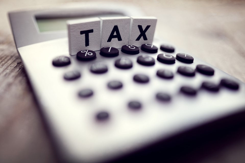 Calculator with the word tax written in wooden block letters