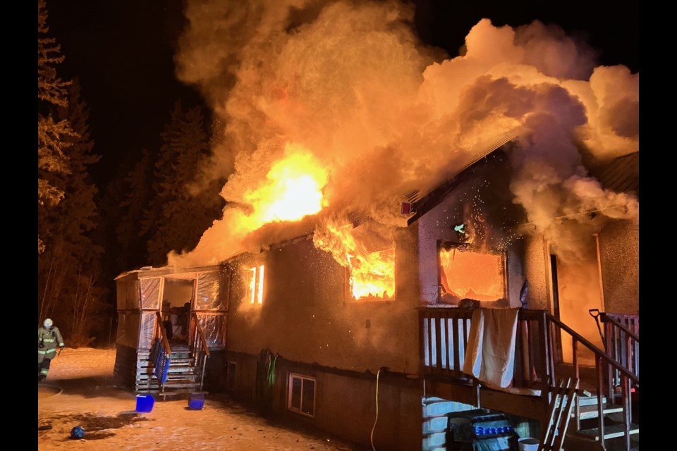 A Lac La Biche County firefighter beside the fully-engulfed home near the Lac La Biche Mission. The home was completely destroyed in the Feb. 28 blaze.